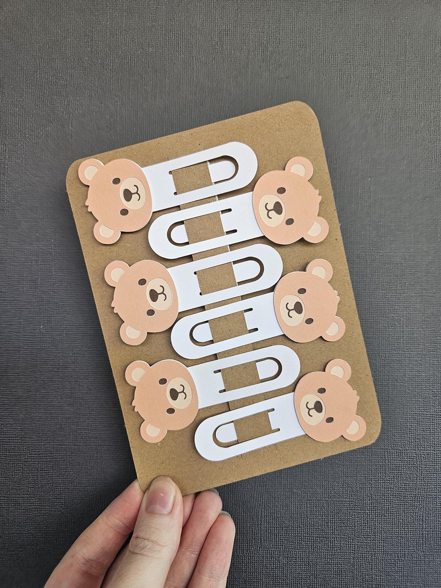 zoomed out view of 6pack of cardstock bear bookmarks blue black background