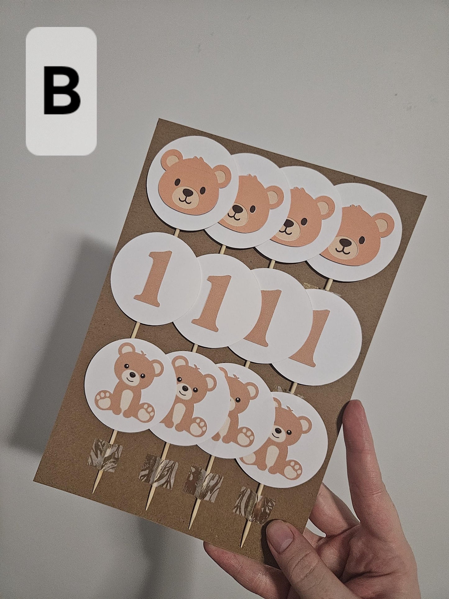 12 pack of Circle shaped bear cupcake toppers. brown and white colours. Number 1, bear head and bear body.