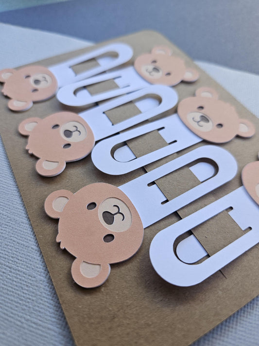 Close up of brown bear cardstock bookmarks clipped onto display packaging