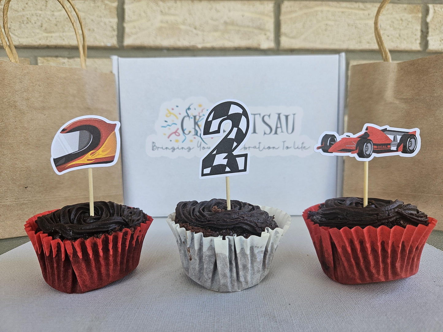 3 race car cupcake toppers displayed on cupcakes