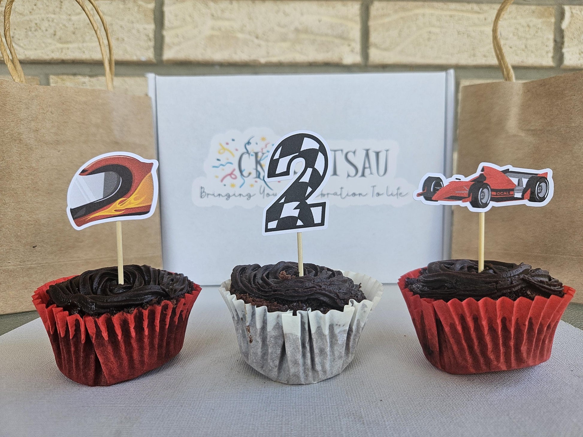 3 race car cupcake toppers displayed on cupcakes