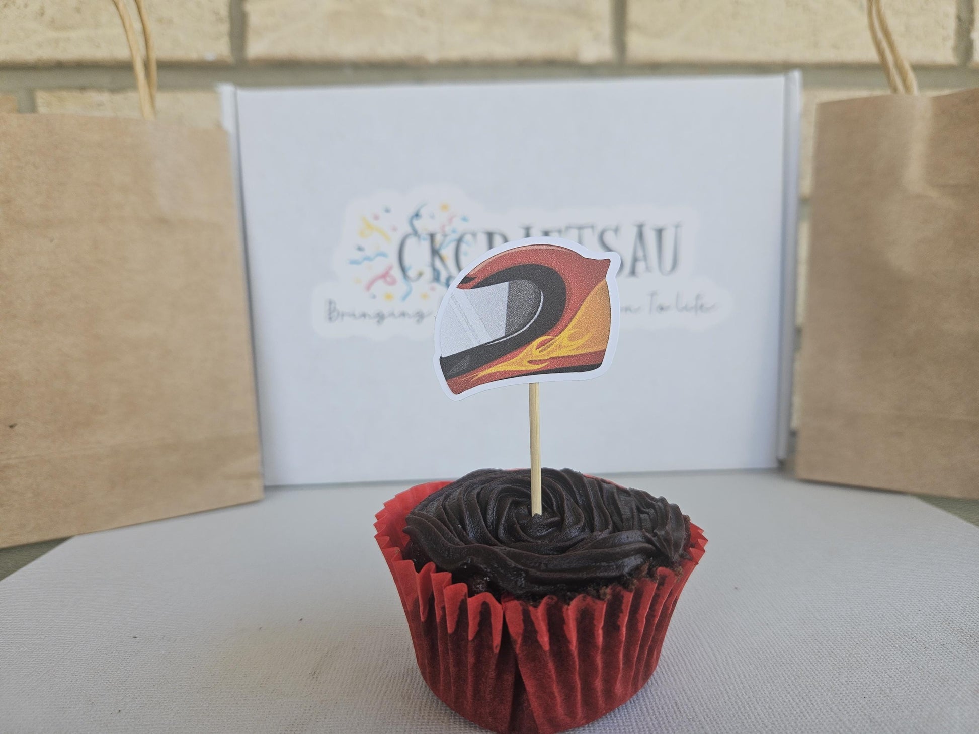race car helmet cupcake topper displayed on cupcake