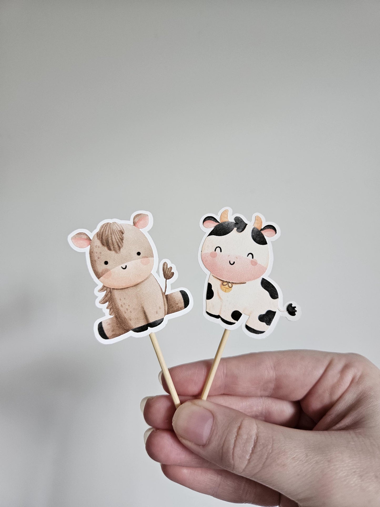 horse and cow cupcake toppers on white background