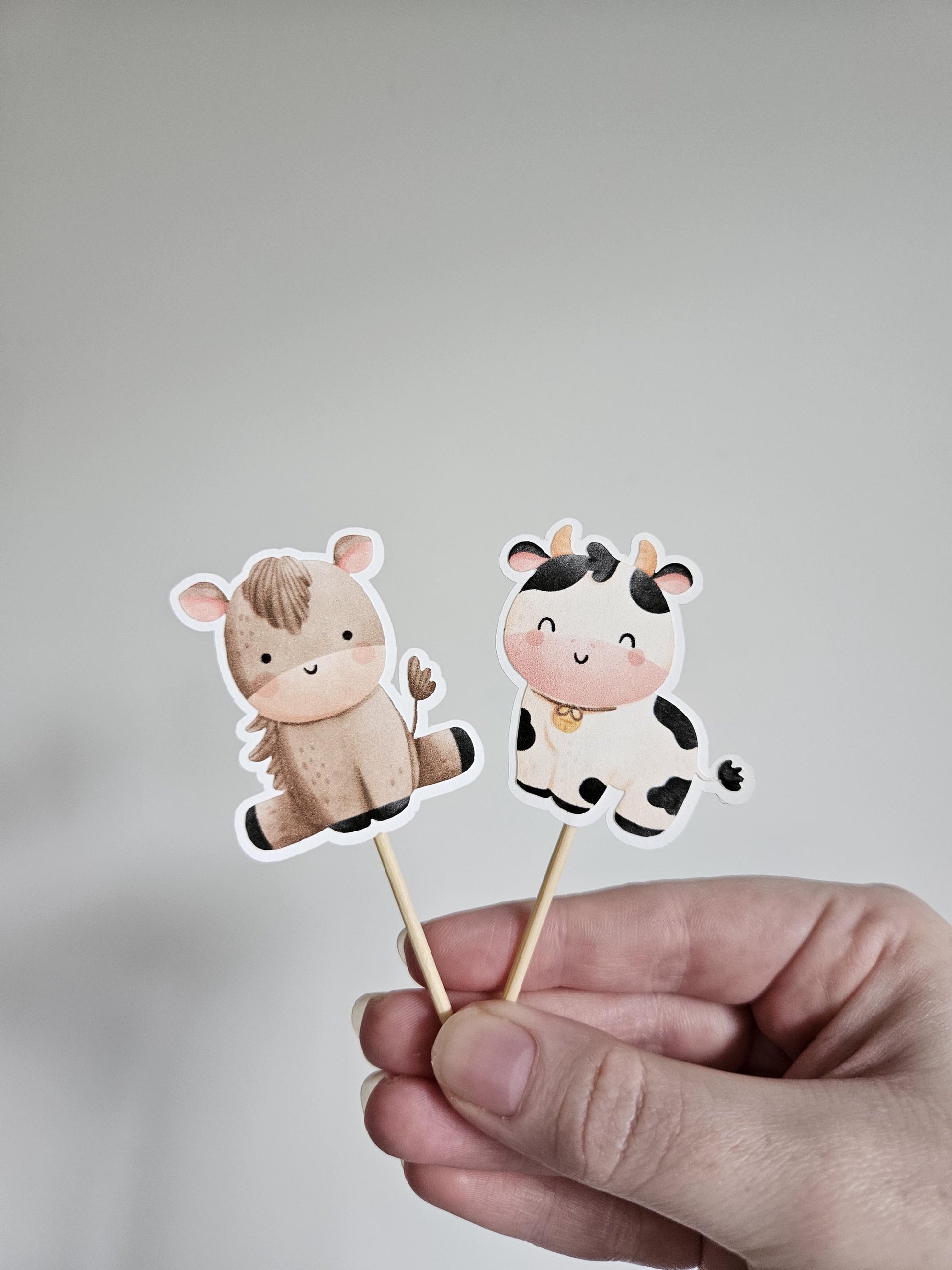 horse and cow cupcake toppers on white background